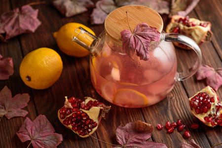 Autumn Beverage: Pomegranate Tea with Lemon and Ginger on Rustic Tableの写真素材