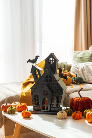 Halloween Decor with Pumpkins and Haunted House on Coffee Table near Cozy Couch