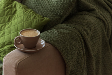 Cup of Hot Coffee Stay on Arm of Cozy Couch by Blanketの写真素材
