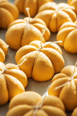 Pumpkin-Shaped Dough Pieces Tied with String on Baking Sheetの写真素材