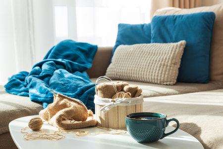 Knitting Setup with Yarn Basket, Mug, and Cozy Couch in Sunlightの写真素材