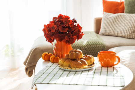 Autumn Living Room with Sofa, Pillows and Pumpkin Cinnamon Buns on Coffee Table
