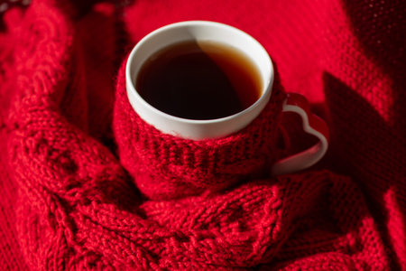 Festive Winter Moment with Knitted Mittens, Sweater, and Hot Drinkの写真素材
