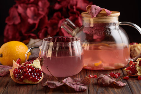 Autumn Beverage: Pomegranate Tea with Lemon and Ginger on Rustic Tableの写真素材