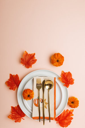 Festive Autumn Table Setting with Napkin, Gold Cutlery, and Seasonal Decorの写真素材