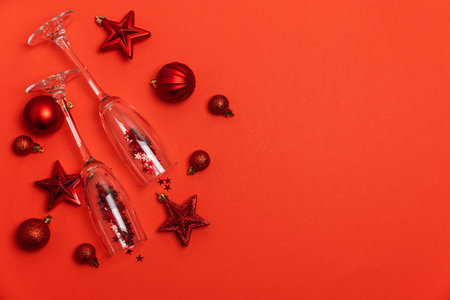 Festive Red Holiday Composition with Champagne Flutes and Christmas Ornamentsの写真素材