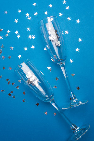 Champagne Bottle and Flutes with Silver Ornaments for New Year Celebration on Blue Backgroundの写真素材