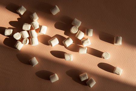 Mini Marshmallows with Shadows on Brown backgroundの写真素材