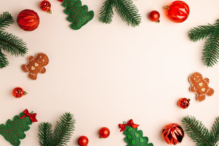 Christmas Flat lay with Red Ornaments and Pine Branches on Beige Background