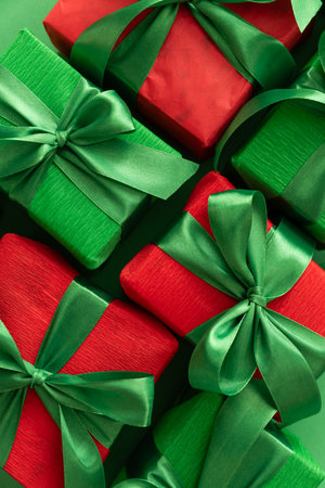 Close-up Christmas Green and Red Gift Boxes on Green Backgroundの写真素材
