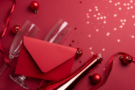 Red Holiday Celebration with Champagne Flutes, Bottle, Ribbon, Ornaments and Red Envelope for congratulationの写真素材