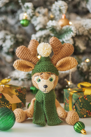 Crocheted Reindeer with Gifts and Christmas Tree in Festive Interiorの写真素材