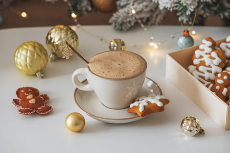 Cup of Hot Coffee with Christmas Gingerbread Cookies and Ornaments in Festive Settingの写真素材