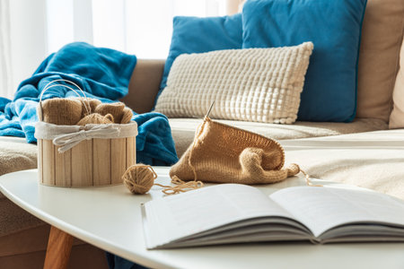 Knitting Setup with Yarn Basket, Book and Cozy Couch in Sunlightの写真素材
