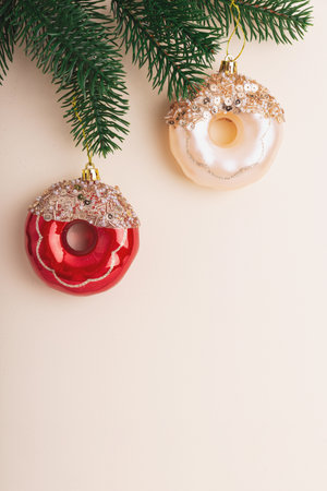 Christmas Donuts Ornaments and Pine Branches on Light Beige Backgroundの写真素材