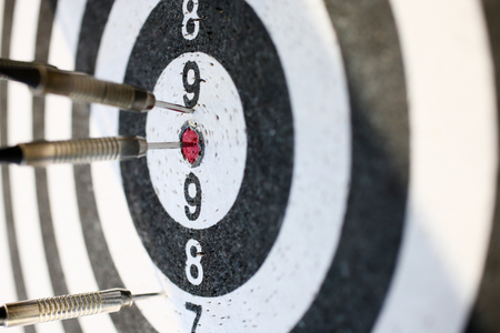 The dart game sticks out in the center of the red target an accurate hit to the targetの写真素材