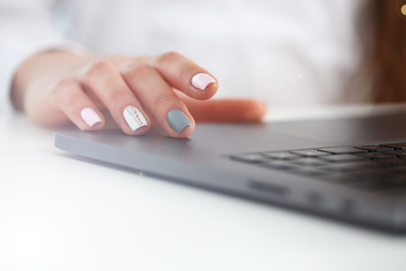 Female arms in typing using laptop pc at office workplace closeup. Accountant finger computer job modern lifestyle web search notebook assistant enter account login password and note credentialの写真素材