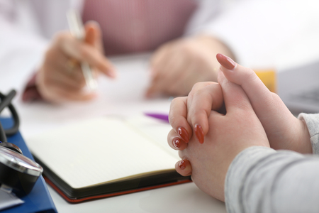 Female doctor hand hold silver pen filling patient history list at clipboard pad. Physical exam er disease prevention ward round visit check 911 prescribe remedy healthy lifestyle conceptの写真素材