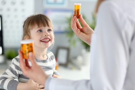 Cute little girl at doctor reception getting medications prescription portraitの写真素材