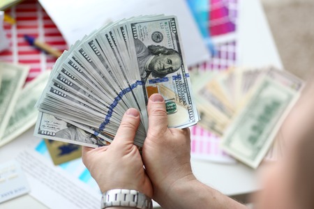Man hold in hand big fat pack of US moneyの写真素材