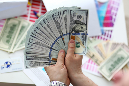 Male hands counting money from huge packの写真素材