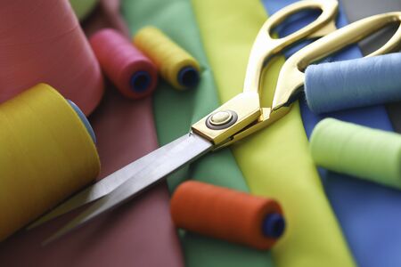 scissors, thread fabric sewing lie on tableの写真素材