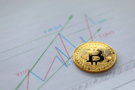 BTC coin lying on financial chart closeupの写真素材