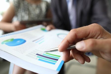Male hand holding financial diagram closeupの写真素材