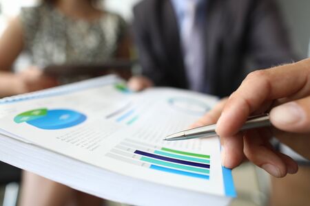 Male hand holding financial diagram closeupの写真素材