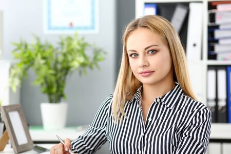 Beautiful blonde elegant female clerk at workplaceの写真素材