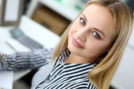 Beautiful blonde elegant female clerk at workplaceの写真素材