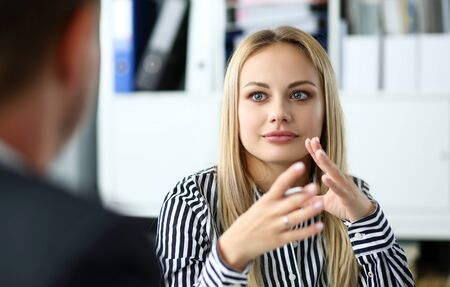 Beautiful blonde clerk sitting at office workplaceの写真素材