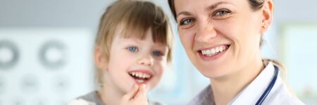 Smiling cute little patient interacting with female doctorの写真素材