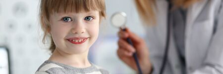 Smiling cute little patient interacting with female doctorの写真素材