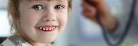 Smiling cute little patient interacting with female doctorの写真素材