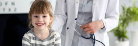 Smiling cute little patient interacting with female doctorの写真素材