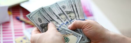 Male hands counting money from huge packの写真素材