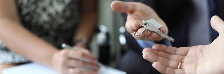 Realtor is handing over key of new apartmentの写真素材