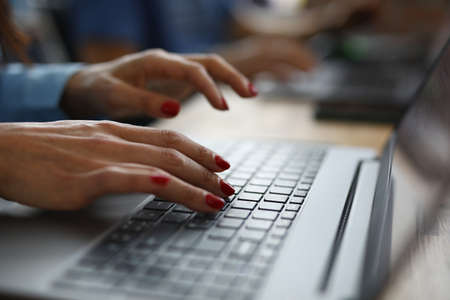 Woman with red nails is typing on keyboard. Online learning professions concept