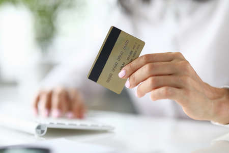 Female hand holds bank plastic card closeupの写真素材