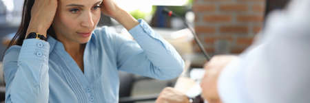 Sad business woman in office hold hands behind head