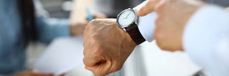 Man in office shows a finger at clockの写真素材
