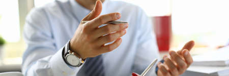 Businessman in an office holds pen in his hand and discusses abusiness plan for 2021 with colleague.の写真素材