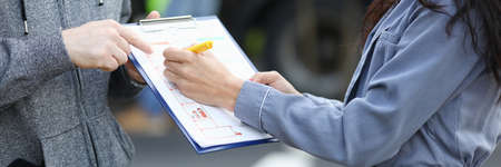 Insurance agent draws up documents after accident.の写真素材