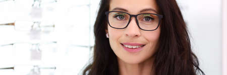 Female consultant stands next to optics showcaseの写真素材
