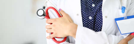 Doctor with stethoscope in his hands stands with folded armsの写真素材