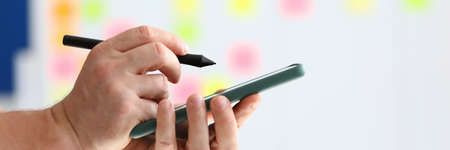 They hold smartphone and pen for electronic signature in their hand.の写真素材