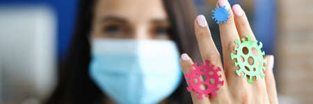 Woman doctor in medical mask shows bacteria on her handの写真素材