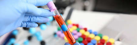 Doctor laboratory assistant holds test tube in his hands with liquidの写真素材