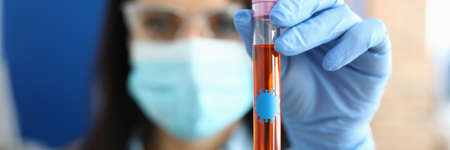 Doctor in gloves holds test tube with covid 19 virus.の写真素材
